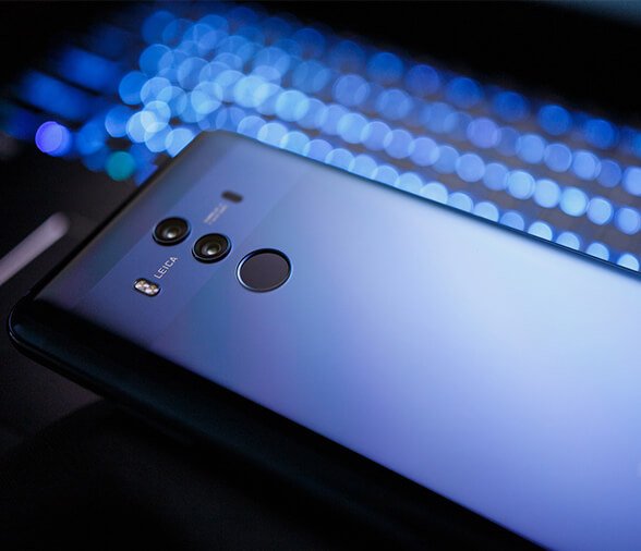blue smart phone over blue backlit keyboard at night