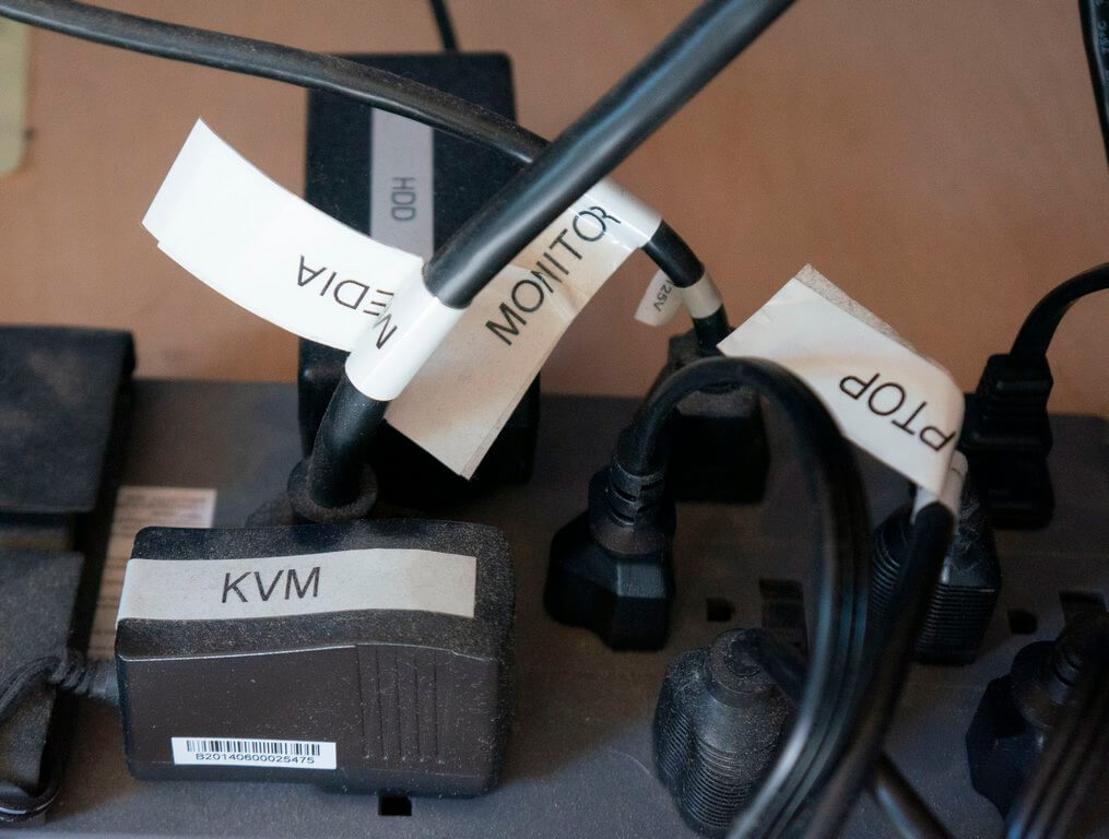 labeled cables connected to power strip showing why a label maker is great for working on computers